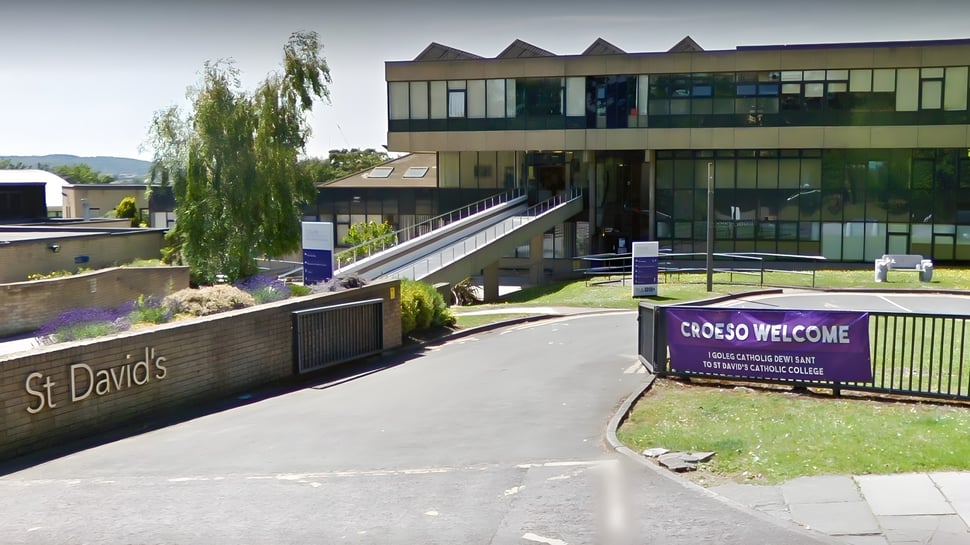 El moderno edificio de varios pisos de St. David's Catholic Sixth Form College se encuentra en un área de césped con un camino delante.