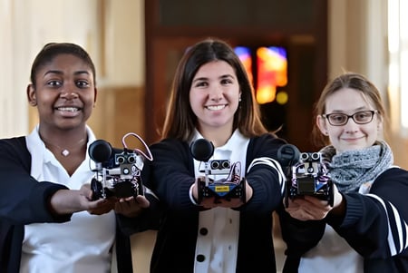 Tres alumnas de St. Dominic's Girl’s Catholic College juegan con controladores en una sala de estar.