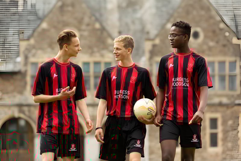Tres estudiantes de la St. Edmunds School están frente a un edificio histórico con ventanas de arco.