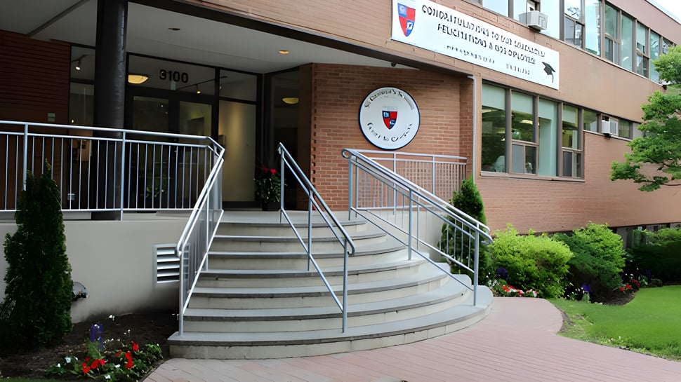 La entrada con escaleras y un letrero en la fachada de ladrillo de la St. George's School of Montreal.