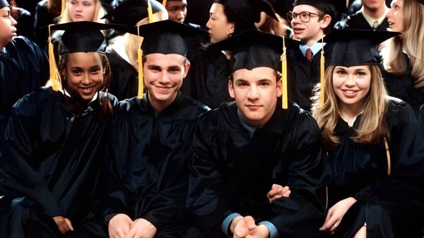 Un grupo de graduadas y graduados en togas negras celebran su graduación en el St. Gerald's College.