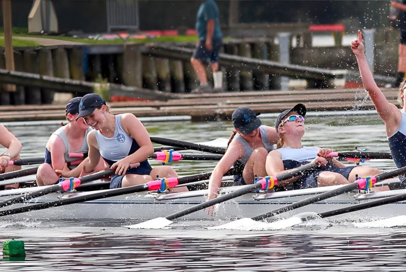 Un grupo de remeros en el agua frente al edificio de St. Hilda's Collegiate School.