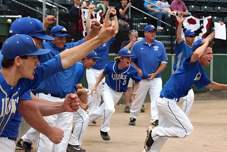 Estudiantes de la St. John Paul II Catholic High School celebran juntos en el campo de béisbol.