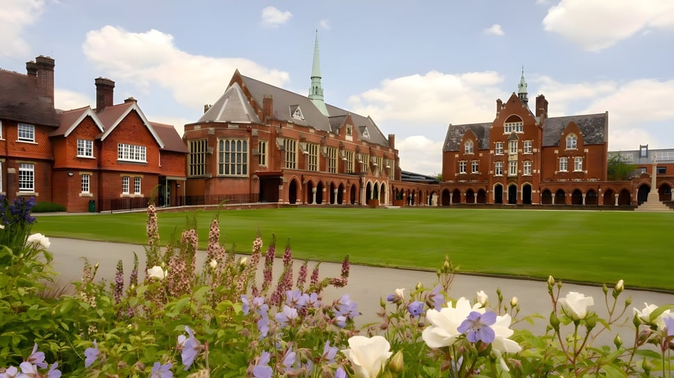El histórico edificio de ladrillo con torre alta en el terreno verde de la St. John’s School en Leatherhead.