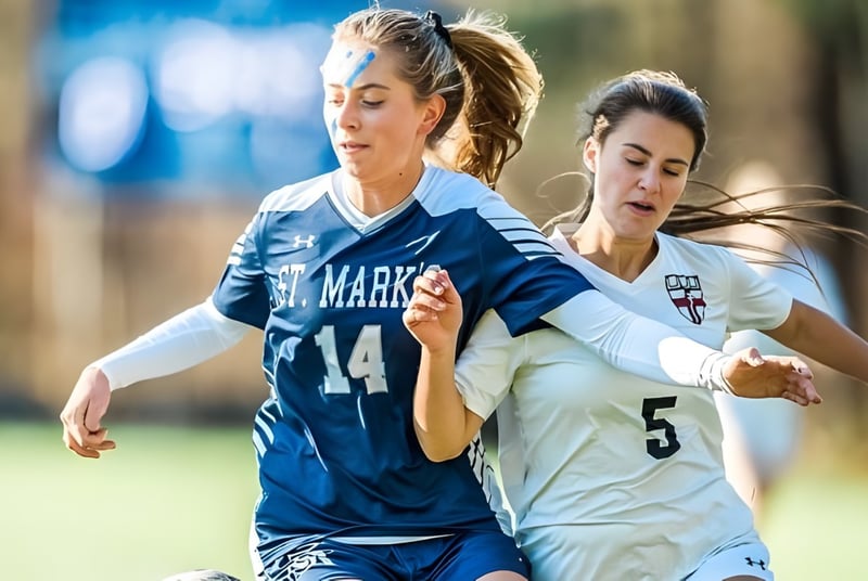 Dos futbolistas de la St. Mark's School luchan en un campo por el balón.