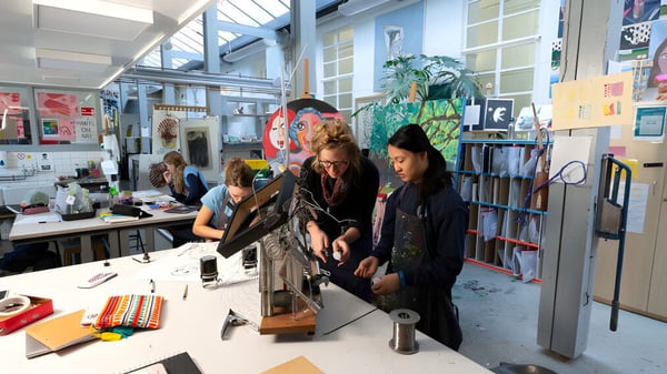 Alumnos de St. Mary's Calne trabajan juntos en un estudio de arte con diferentes materiales y obras de arte en las paredes.