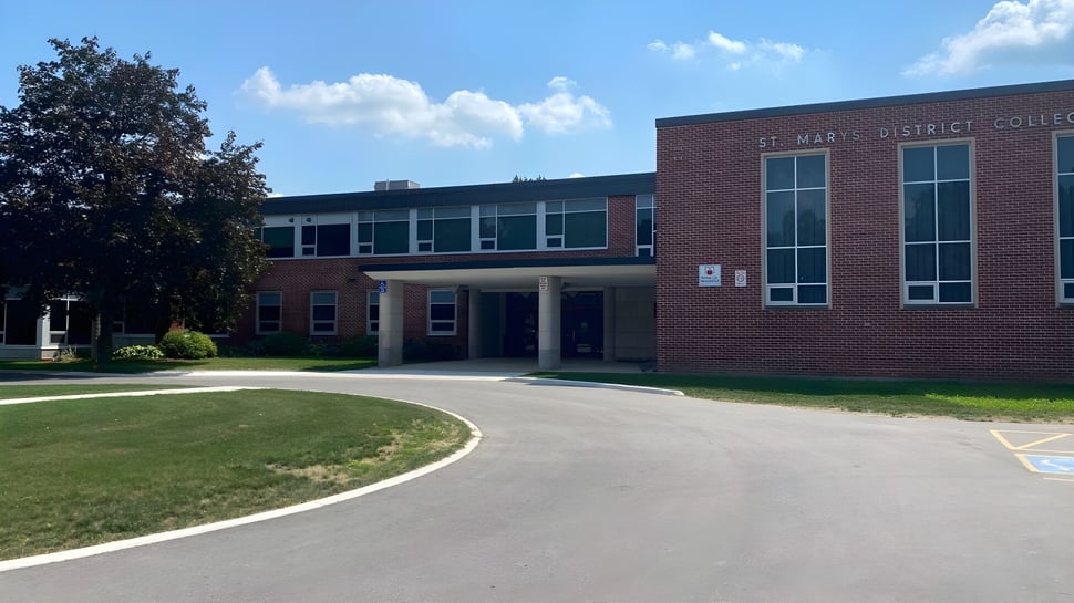 El edificio de ladrillo del St Mary’s District & Vocational Collegiate Institute está rodeado de un camino pavimentado y áreas verdes.