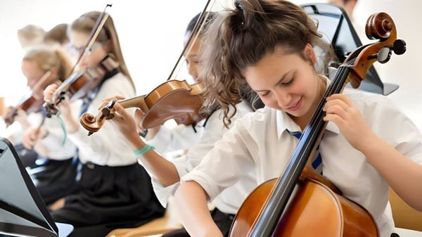 Un grupo de jóvenes músicos toca violines en la clase de la St. Mary’s Music School.