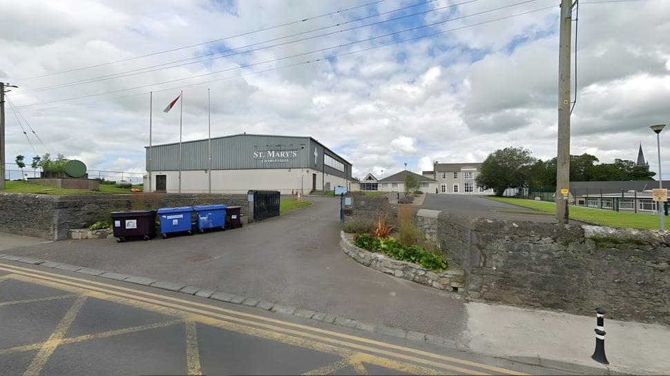 El edificio de la St. Mary's Secondary School en Charleville está rodeado de una calle pavimentada y muros de piedra.
