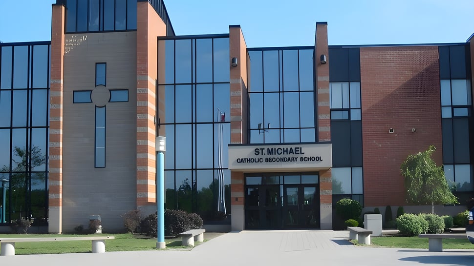 El moderno edificio de la St. Michael Catholic Secondary School con símbolo de cruz y cuidado exterior.