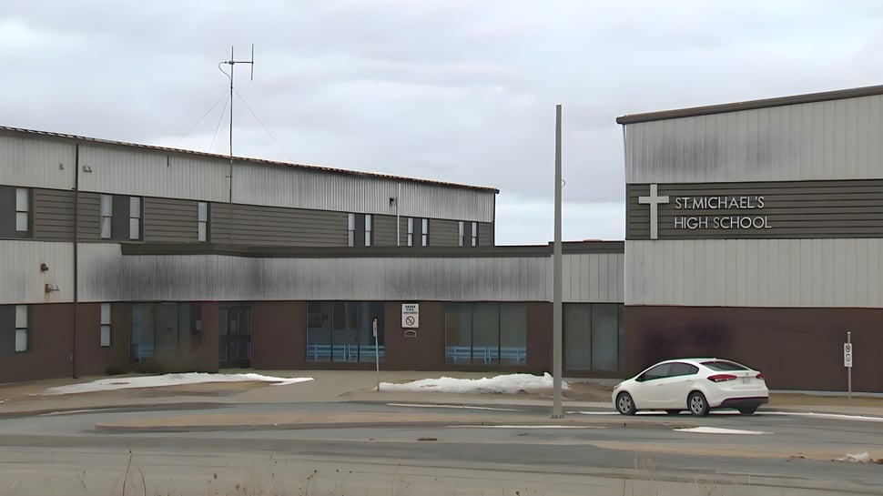 Se puede ver el gran edificio industrial gris frente al estacionamiento de St. Michael's Regional High.