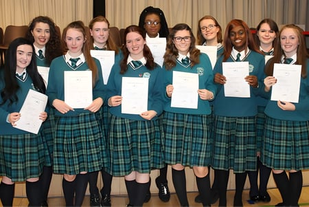 Un grupo de alumnas y alumnos de la St. Paul’s Secondary en Galway sostiene sus premios en un aula.