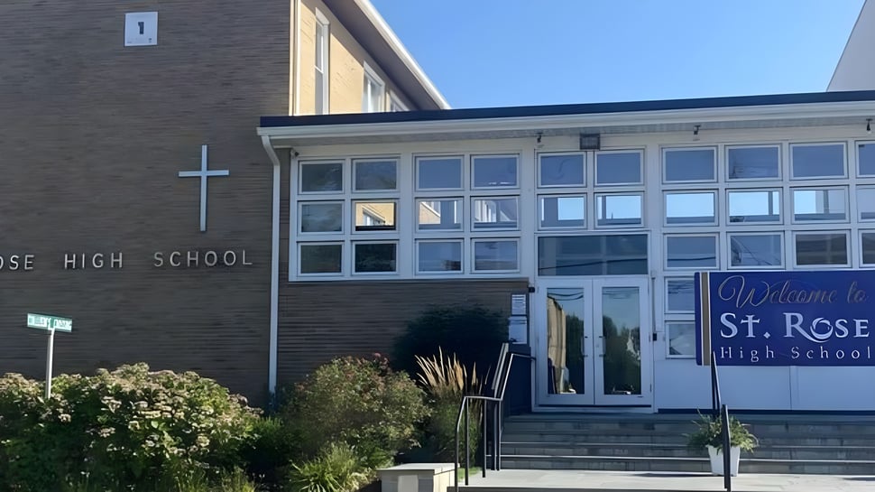 Se puede ver el edificio de ladrillo de la St. Rose High School con grandes ventanas y un letrero de entrada acogedor.