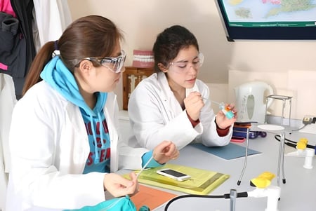 Dos estudiantes del St. Andrew’s College Cambridge trabajan juntas en el laboratorio en experimentos científicos.