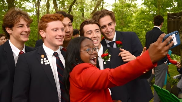 Un grupo de estudiantes del Stanstead College se toma un selfie juntos en el área verde al aire libre.