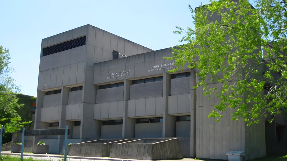 El moderno edificio escolar del Stephen Leacock Collegiate Institute con grandes ventanas y una entrada destacada está rodeado de árboles verdes.