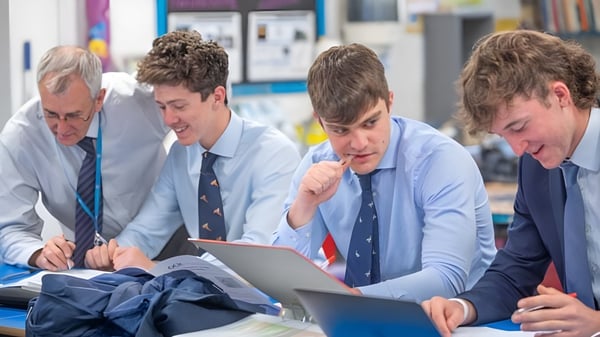 Estudiantes de la Stephen Perse Foundation discuten juntos en un portátil en un aula.