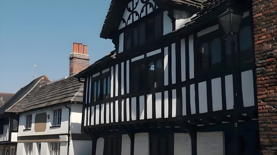 El edificio histórico de entramado de madera en el campus de Steyning Grammar School and Sixth Form se encuentra bajo un cielo azul claro.
