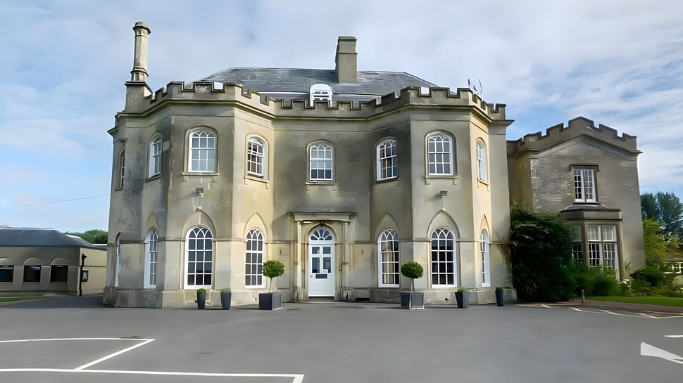 El edificio de la Stonar School muestra un diseño arquitectónico distintivo y está rodeado de un área pavimentada con árboles.