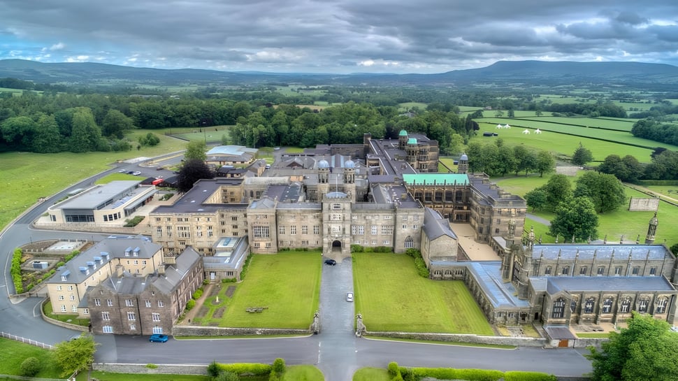 El castillo medieval en el terreno del Stonyhurst College está rodeado de un paisaje verde y colinas.