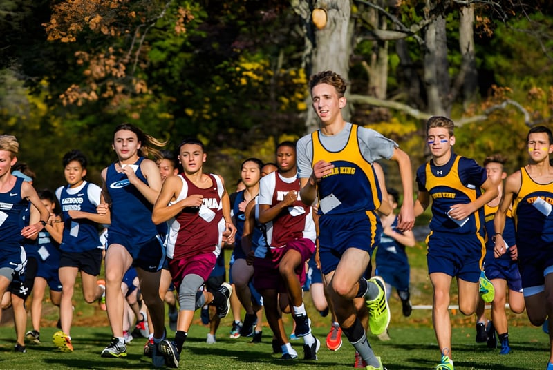 Estudiantes de la The Storm King School corren en una carrera de campo a través por un bosque otoñal.
