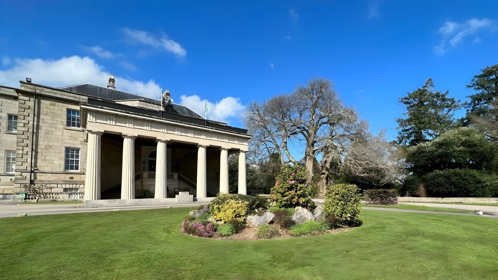 El clásico edificio con columnas en el campus de la Stover School está rodeado de un césped cuidado y grandes árboles.