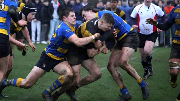 Dos jugadores de rugby con camisetas opuestas realizan un contacto corporal en el campo durante un partido en la Stowe School.