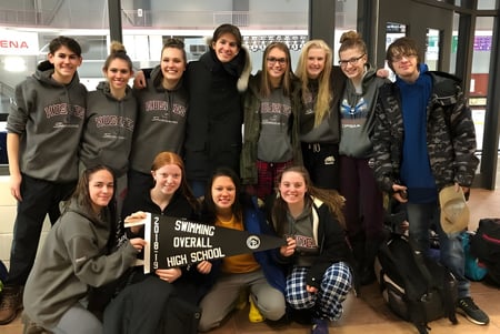 Un grupo de estudiantes de la Stratford District Secondary School posan juntos en una arena deportiva.