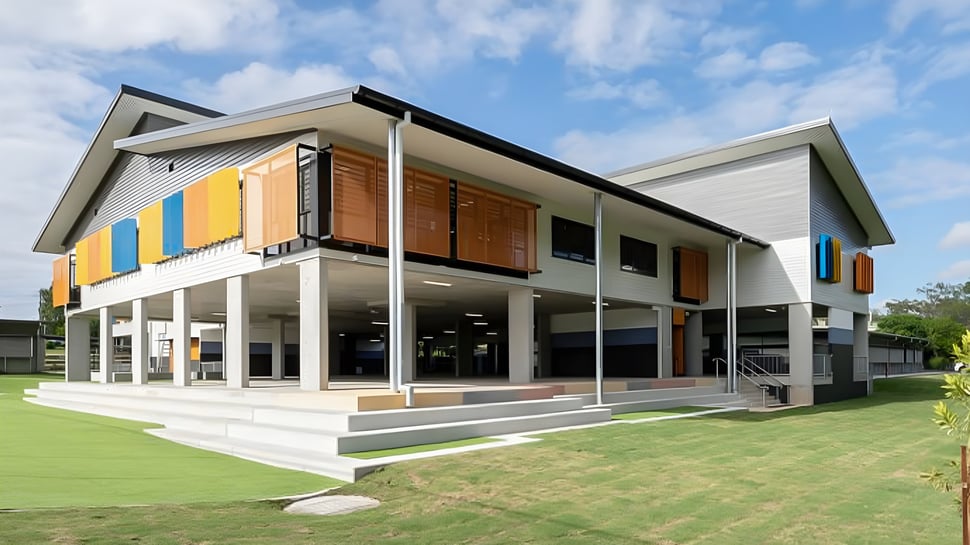 El moderno edificio principal de dos pisos del Stretton State College con fachada colorida y un césped circundante.