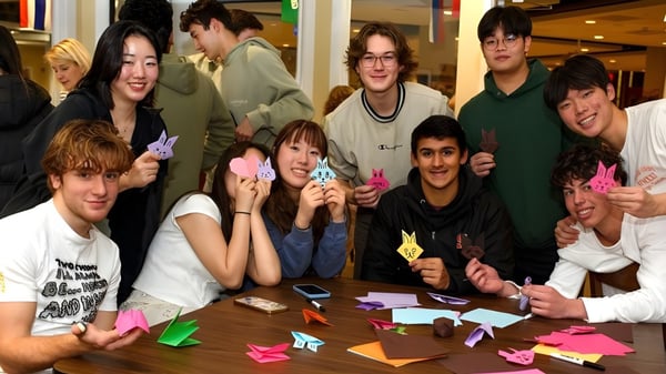 Estudiantes de la Suffield Academy trabajan juntos en una mesa con coloridas figuras de origami.