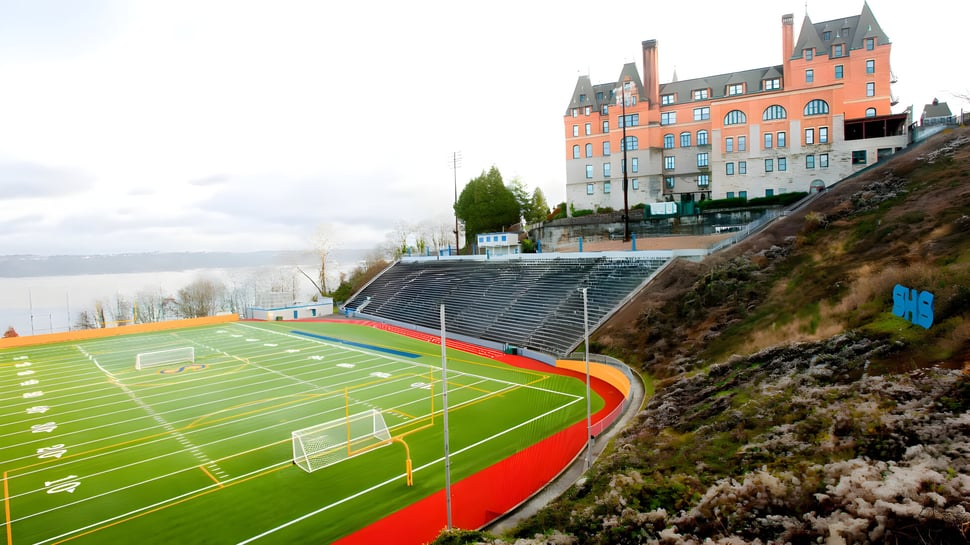 El colorido campo deportivo con una portería de fútbol y un paisaje montañoso de fondo en el campus de Tacoma Public Schools.
