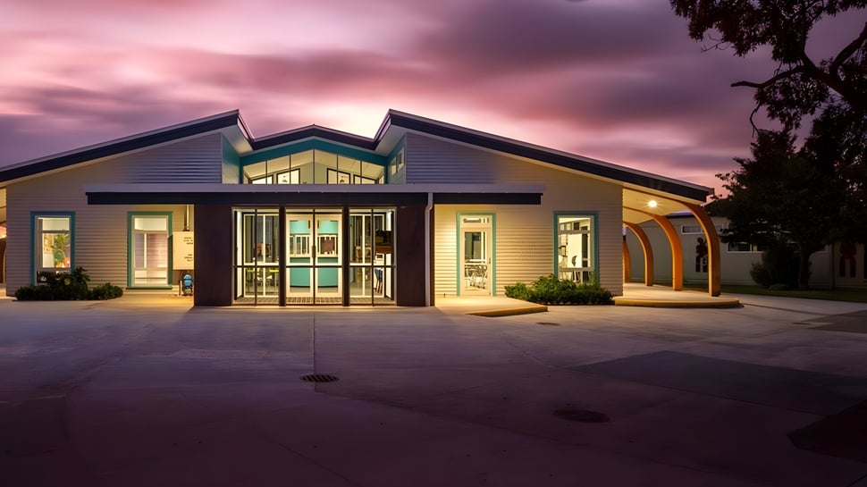 El moderno y colorido edificio de la Taradale High School con grandes ventanas y entrada cubierta frente a un cielo nublado.