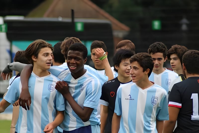 Un grupo de jóvenes futbolistas se reúne en el campo de TASIS The American International School in England.