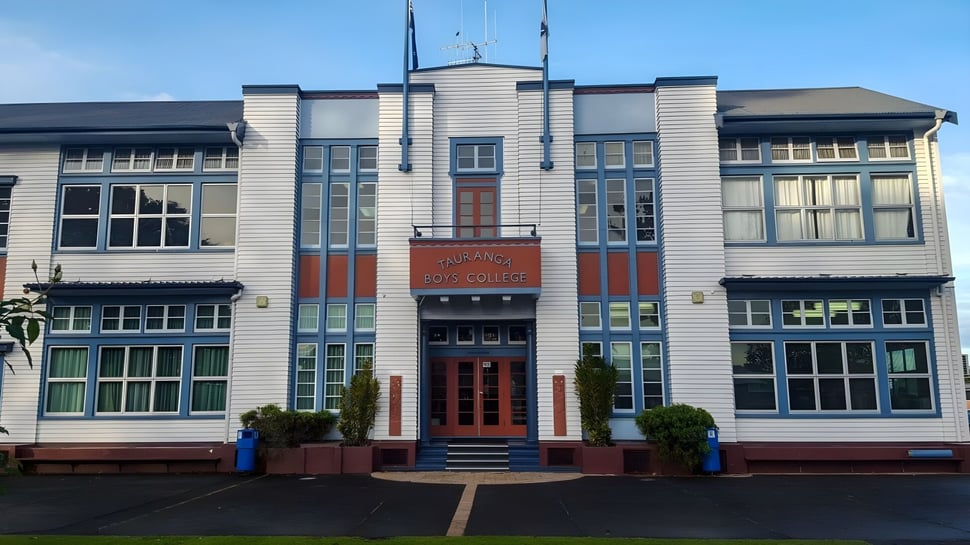 El edificio de varios pisos con fachada Art-Deco del Tauranga Boy's College está rodeado de un área pavimentada y zonas verdes.