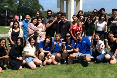 Un gran grupo de jóvenes se reúne en un campo en el campus de la The Academy MiraCosta.