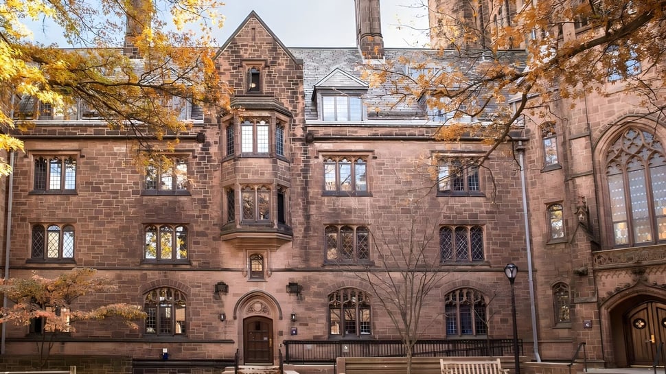 El edificio de piedra de estilo medieval de The Beekman School está rodeado de árboles con colores otoñales.
