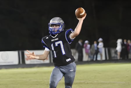 Un jugador de fútbol americano de The Beekman School está en el campo y se prepara para lanzar.