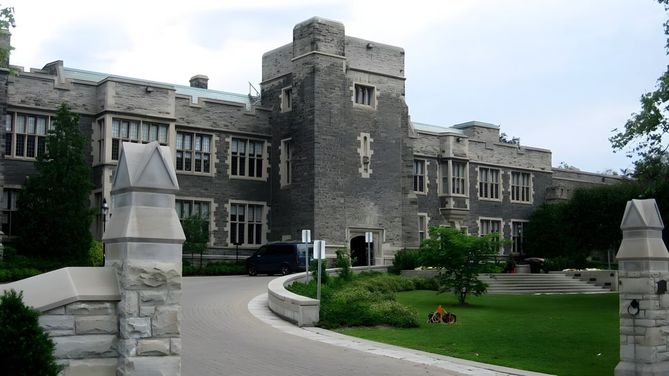 El impresionante edificio de piedra de The Bishop Strachan School está rodeado de césped bien cuidado con un camino hacia la entrada.