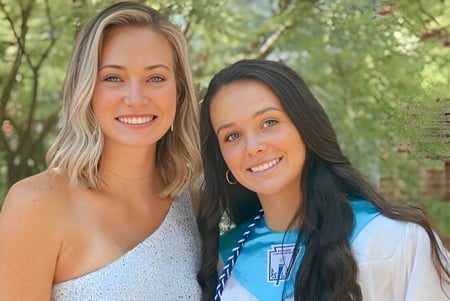 Dos alumnas sonrientes están juntas en el verde exterior de The Calverton School.