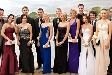 Un grupo de personas vestidas formalmente está al aire libre con el horizonte de la ciudad de fondo en el campus de The Friends’ School.