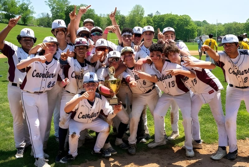 Estudiantes de The Harvey School celebran juntos en el campo de béisbol su victoria.