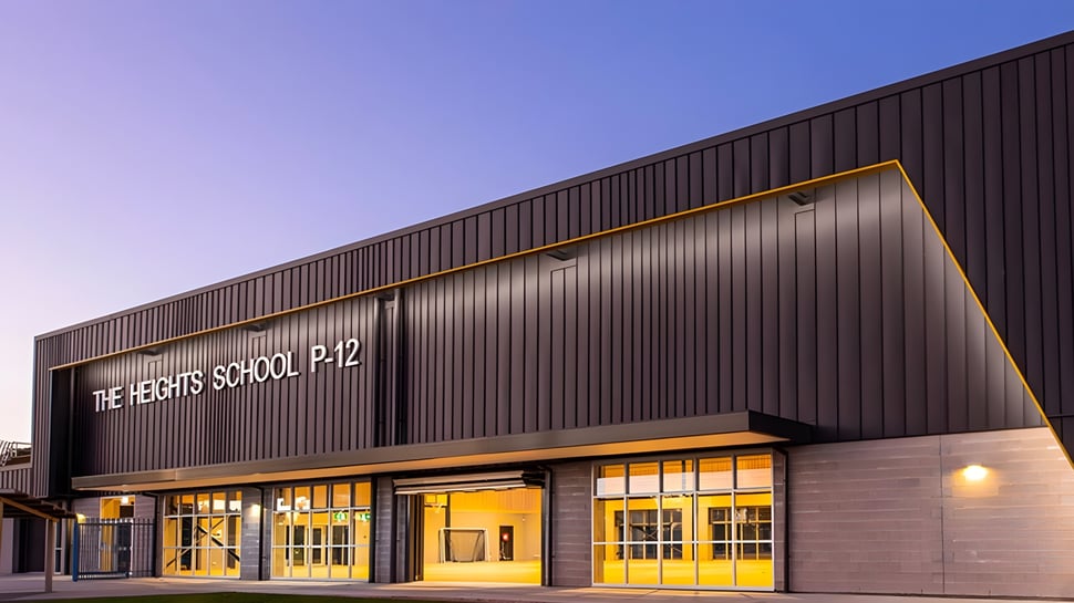 El gran edificio con la inscripción The Heights School P-12 frente a un cielo azul claro.