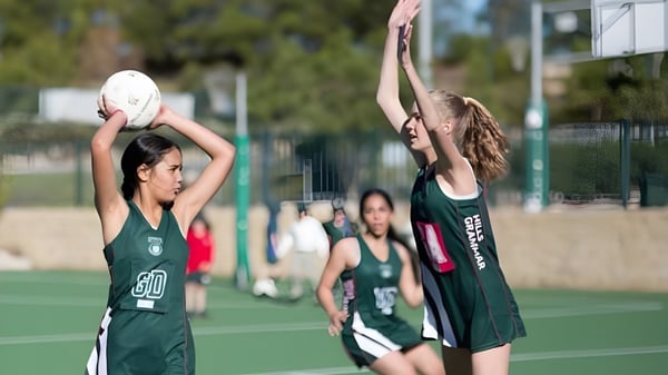 Dos jugadoras de baloncesto juegan en la cancha de baloncesto de The Hills Grammar School.