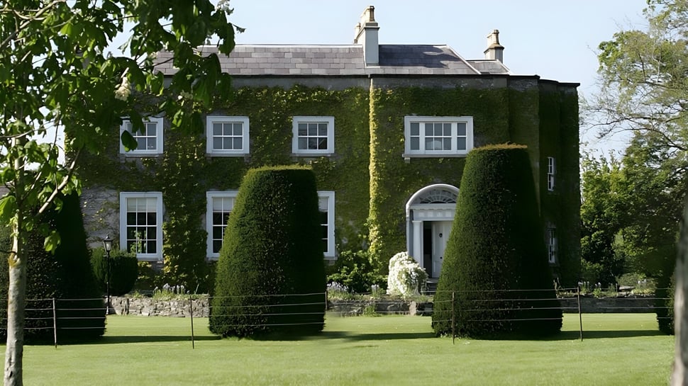 La propiedad de The Kings Hospital está rodeada de un cuidado verde y una valla de hierro forjado.