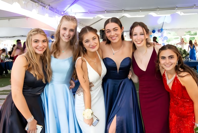 Un grupo de jóvenes estudiantes de The Kings Hospital posan en un ambiente festivo al aire libre con globos de colores de fondo.