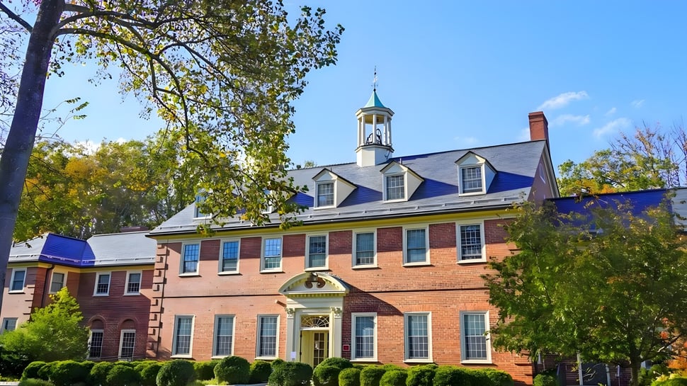 El edificio histórico de ladrillo con torrecitas y ventanas de colores en el terreno de The Madeira School.