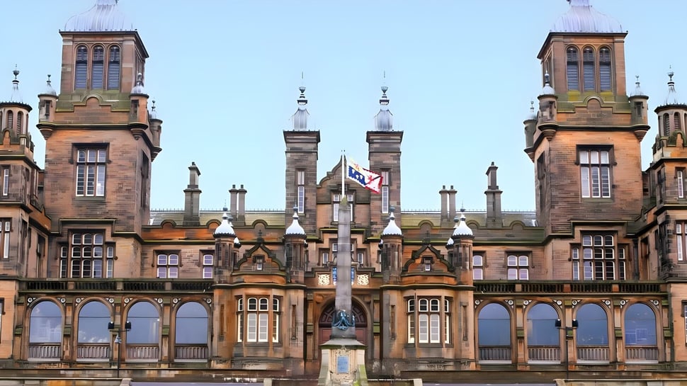 El edificio histórico de The Mary Erskine School con torres y arcos bajo un cielo despejado.