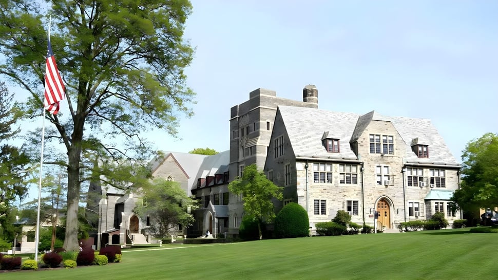 El edificio principal de piedra con torre de The Masters School está rodeado de césped bien cuidado y árboles.