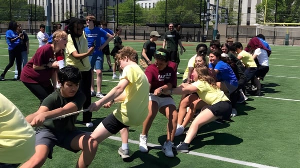 Un grupo de estudiantes de The Newman School participa en una actividad deportiva en el campo de deportes.