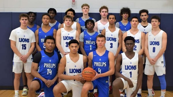 Un grupo de jóvenes jugadores de baloncesto posan en el gimnasio de The Phelps School.